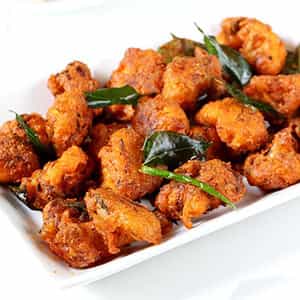 Gobi 65,Fried crispy cauliflower florets tossed in spicy Indian curry sauce